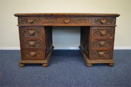 A good oak twin pedestal writing desk with carved panel sides. Est. £400 - £450.