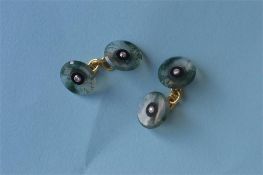 A pair of unusual moss agate, onyx and diamond circular cufflinks on gold chains. Est. £300 - £350.