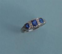 A sapphire and diamond seven stone ring in carved white gold setting. Est. £120 - £150.