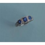 A sapphire and diamond seven stone ring in carved white gold setting. Est. £120 - £150.