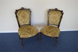 A pair of upholstered chairs with carved back rail. Est. £50 - £60.