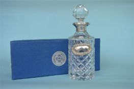 A good quality boxed Millenium hallmark silver mounted decanter with matching label, in fitted