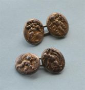 A pair of silver chased cufflinks decorated with cherubs. By Alfred Phillips. Est. £200 - £250.