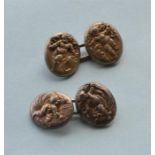 A pair of silver chased cufflinks decorated with cherubs. By Alfred Phillips. Est. £200 - £250.