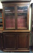 A mahogany two piece bookcase with glazed doors on pedestal foot. Est. £160 - £180.