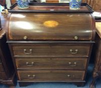 A mahogany Edwardian cylinder top desk with three drawers, fitted interior and shell motif. Est. £