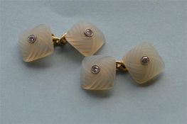 An unusual pair of diamond and crystal cufflinks with carved decoration on high carat suspension