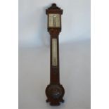 An oak stick barometer attractively carved with scrolls. By W. Ladd of Chancery Lane, London.