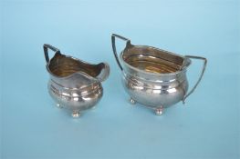 A small cream and sugar basin with gadroon rim on ball feet. Chester modern. By A Bros. Approx.