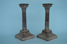 A pair of good quality corinthian column candlesticks on step base and reeded stem. Sheffield