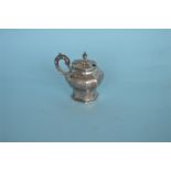 A good quality Victorian mustard pot with engraved flowers and scrolls and embossed handle.