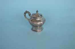 A good quality Victorian mustard pot with engraved flowers and scrolls and embossed handle.