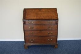 A slim oak four drawer bureau on bracket feet. Est. £70 - £80.