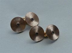 A pair of stylish circular engine turned cufflinks in platinum and gold with central cabouchon