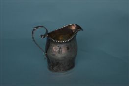 A good Georgian style helmet shaped cream jug. Birmingham 1907. By B&M. Est. £40 - £50.