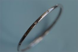 An 18ct diamond set bangle with concealed clasp in 18ct white gold. Est. £400 - £450.