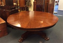 A reproduction mid sized expanding Duke dining table, the top in eight sections on a turned
