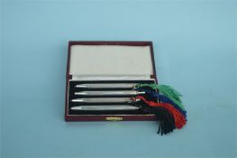 A boxed set of four good quality bridge pens with tassle ends. Marked Sterling. Est. £45 - £50.