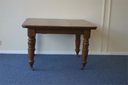A good oak extending table on turned supports. Est. £70 - £80.