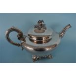 A Victorian helmet shaped teapot with rose cap finial and scroll decorated feet. London 1844. By