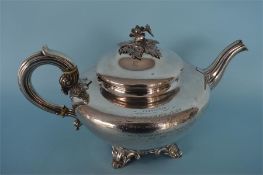 A Victorian helmet shaped teapot with rose cap finial and scroll decorated feet. London 1844. By