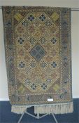 A Persian rug with diamond decoration on ivory background. Approx. 164 cms x 105 cms. Est. £50 - £