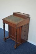 An Edwardian slope top Davenport with four drawers and hinged top. Est. £70 - £80.