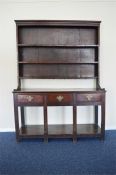 An attractive Antique oak small kitchen dresser with three drawers, shelves and panelled top.