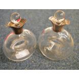 An unusual pair of glass oil and vinegar bottles shaped with open centres and double pouring lips.