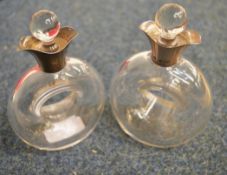 An unusual pair of glass oil and vinegar bottles shaped with open centres and double pouring lips.