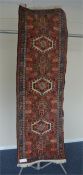 A small Hamadan runner with seven medallions on red ground. Approx. 200 cms x 63 cms. Est. £30 - £
