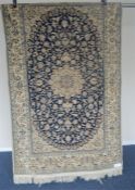 A modern Persian rug with white medallion on blue background. Approx. 115 cms x 192 cms. Est. £