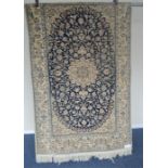 A modern Persian rug with white medallion on blue background. Approx. 115 cms x 192 cms. Est. £