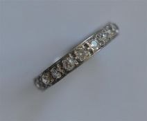 A good diamond full eternity ring in engraved white gold band. Est. £450 - £500.