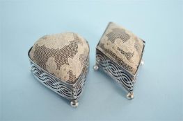 A pair of pierced pin cushions on ball feet, one in the form of a heart, the other in the form of
