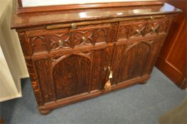 An oak Gothic sideboard with two drawers and two doors. Est. £80 - £100.