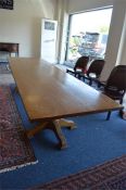 A massive oak twin pedestal boardroom table on four tapered supports and plank top. Over three