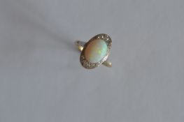 A good Art Deco opal and diamond oval cluster ring in two colour gold. Est. £350 - £400.