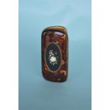 A good quality tortoiseshell pietra dura spectacle case with hinged sides decorated with a flower.