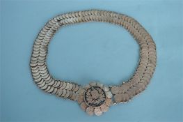 A Continental mesh belt, mounted with numerous coins. Approx. 170 grams. Est. £30 - £40.