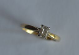 A small emerald cut single stone ring in two colour gold 18ct setting. Est. £400 - £450.