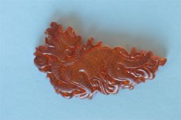 A good expertly carved amber panel in the form of a dragon with textured body. Approx. 6.5 cms long.