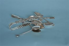 A pair of early Georgian sugar tongs with floral decoration, together with other various spoons.
