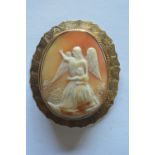 A large oval cameo of an angel in gold engraved frame. Est. £200 - £250.