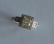 A good diamond cluster ring, the central princess cut stone weighing 1.02 carats, surrounded by