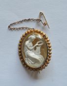 An oval gold brooch with crystal centre depicting a lady playing a harp. Est. £200 - £250.