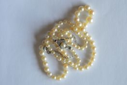 A good string of pearl beads with paste clasp. Est. £15 - £20.