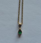 An emerald single stone drop pendant on fine link chain. Est. £30 - £40.