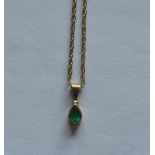 An emerald single stone drop pendant on fine link chain. Est. £30 - £40.