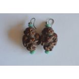 A pair of Chinese carved ear pendants mounted with loop tops. Est. £30 - £40.
